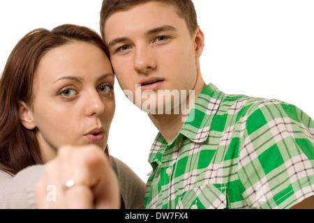 Junges Paar zeigt auf die Kamera mit ihren Köpfen nahe beieinander liegen, Detailansicht mit Fokus auf ihren Gesichtern, isoliert auf weiss. Stockfoto