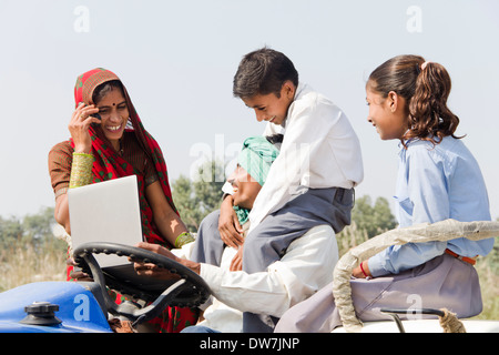 Indischen Bauern fahren Traktor mit Familie und Frau im Gespräch Stockfoto