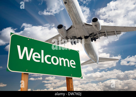 Begrüßen Sie grüne Verkehrszeichen und Flugzeug über dramatische blauer Himmel mit Wolken. Stockfoto