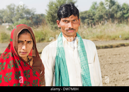 Indischen Bauern stehen mit Frau in Plowed Feld Stockfoto