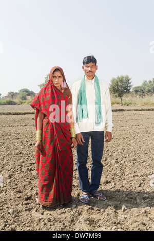 Indischen Bauern stehen mit Frau in Plowed Feld Stockfoto