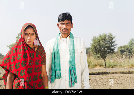 Indischen Bauern stehen mit Frau in Plowed Feld Stockfoto