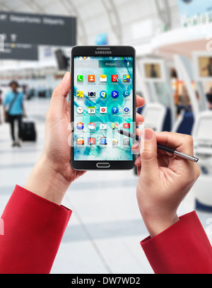 Frau Hände mit Samsung Galaxy Note III Smartphone am Flughafen Stockfoto