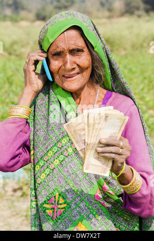 1 indische Frau stehen und reden mit mobile Stockfoto