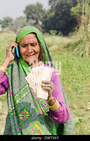 1 indische Frau stehen und reden mit mobile Stockfoto