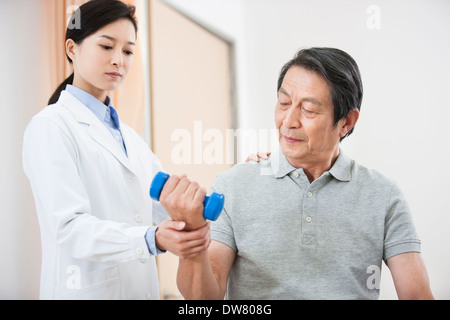 Ältere Patienten Training mit Hantel unter ärztlicher Hilfe Stockfoto