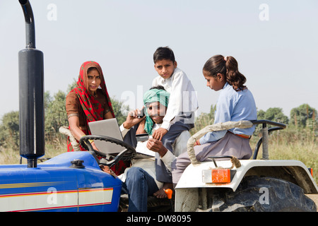 Indische Landwirt Traktor mit Familie zu fahren und reden Stockfoto