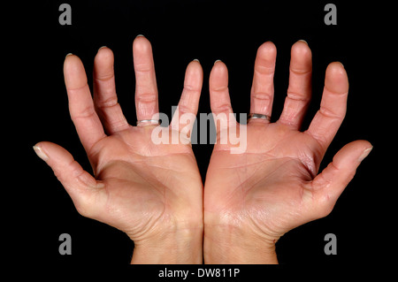 Frau mit offenen Händen. Reinigen Sie auf schwarzem Hintergrund. Stockfoto