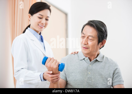 Ältere Patienten Training mit Hantel unter ärztlicher Hilfe Stockfoto