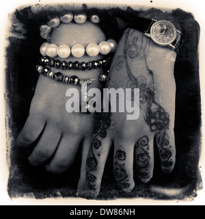 Ein kompliziertes Henna-Design auf dem Rücken und den Fingern einer Frau auf der Insel Sansibar Ostafrika. Die Designs können symbolische Bedeutungen haben, wobei verschiedene Muster Dinge wie Schönheit, Glück, Schutz oder Fruchtbarkeit darstellen. Die Dunkelheit des Henna-Flecks wird auch in einigen Kulturen als bedeutend angesehen, wobei ein dunklerer Fleck eine tiefere Liebe zwischen zwei Menschen in einer Ehe symbolisiert. Stockfoto