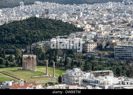 Antike Stätte der Tempel des Olympischen Zeus gegen die moderne Skyline von Athen gesehen, Stockfoto