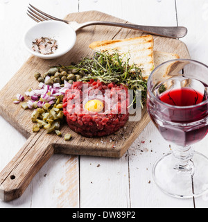 Rindertatar mit Kapern und frischen Zwiebeln an Bord mit Wein Stockfoto