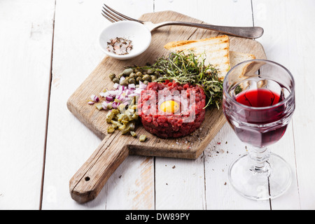 Rindertatar mit Kapern und frischen Zwiebeln an Bord mit Wein Stockfoto