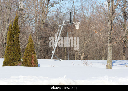 Basketball-Ständer und Net auf ein Gericht außerhalb mit Schnee bedeckt Stockfoto