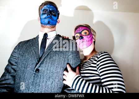 Eine elegant gekleidete junge Paar tragen Zombie Stil Gesicht malen strike eine Horror-Pose für die Kamera. Stockfoto