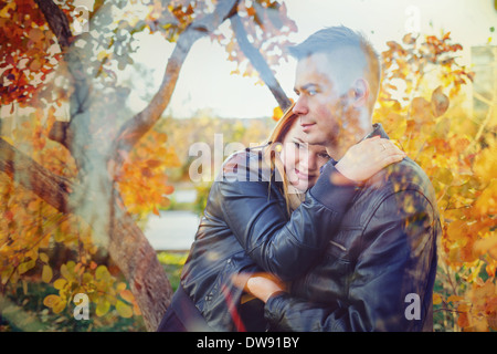 Attraktives junges Paar in einem Stadtpark vor dem Hintergrund der Bäume umarmen Stockfoto