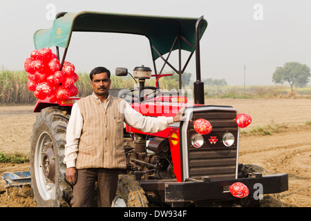 1 indische Bauern stehen mit einem Traktor und Feld im Bereich Vorbereitung Stockfoto