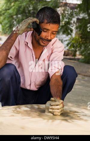 1 indische Dorfbewohner machen Töpfe und reden Stockfoto