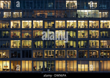 Bürogebäude mit beleuchteten Fenstern, Menschen bei der Arbeit, Medienhafen, Düsseldorf, Nordrhein-Westfalen, Deutschland Stockfoto