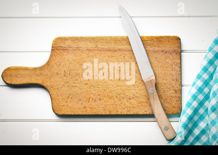Draufsicht auf Schneidebrett mit Messer auf weißer Holztisch Stockfoto