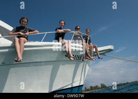 Touristen sitzen am Rand einer Yacht Utila Island Bay Islands Honduras Stockfoto