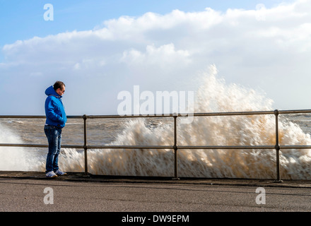 Man stützte sich auf Geländer neben der Wellen brechen, Sussex, UK Stockfoto