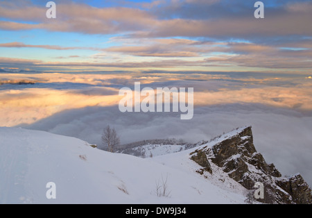 Winterlandschaft bei Sonnenuntergang mit nebligen Tal. Stockfoto