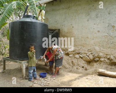 Regenwasser Ernte. Aufnahme von Wasser aus großen Tank das Wasser vom Dach gesammelt. Stockfoto