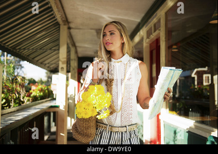 Junge Frau mit Karte in der Veranda Stockfoto