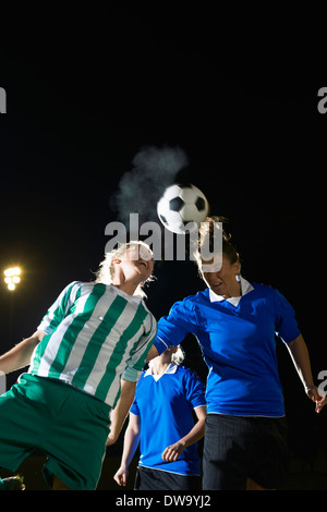 Weibliche Fußball-Spieler schlagen Ball mit Kopf Stockfoto