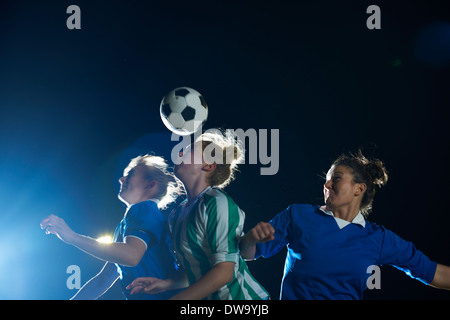 Weibliche Fußball-Spieler schlagen Ball mit Kopf Stockfoto