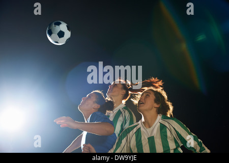 Weibliche Fußball-Spieler schlagen Ball mit Kopf Stockfoto