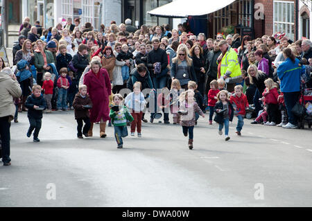 Alcester, Warwickshire, England, UK. 4. März 2014. Kinder Rennen in einem jährlichen Faschingsdienstag Pfannkuchen-Rennen in Alcester High Street. Bildnachweis: Colin Underhill/Alamy Live-Nachrichten Stockfoto