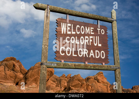 Willkommen Sie bei bunte Colorado am Straßenrand Holzschild mit rotem Sandstein Felsen im Hintergrund Stockfoto