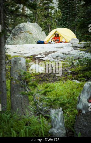 Frau, camping in der Nähe von Kratersee am Fuße des Lone Eagle Peak, indische Peaks Wilderness, Colorado, USA Stockfoto