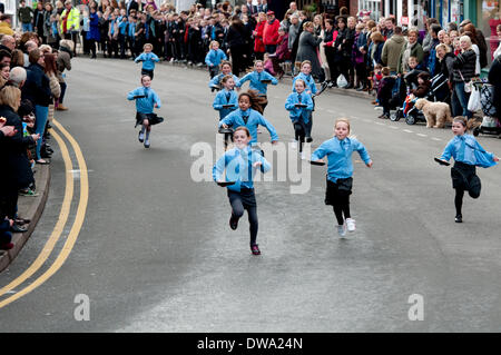 Alcester, Warwickshire, England, UK. 4. März 2014. Schulkinder-Rennen in einem jährlichen Faschingsdienstag Pfannkuchen-Rennen in Alcester High Street. Bildnachweis: Colin Underhill/Alamy Live-Nachrichten Stockfoto