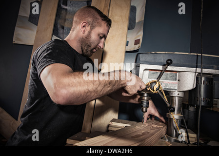 Männliche Schreiner Bohren Holzbrett in Werkstatt Stockfoto