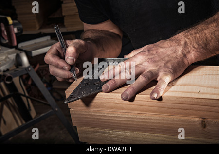 Nahaufnahme eines männlichen Zimmermann mit Geodreieck in Werkstatt Stockfoto