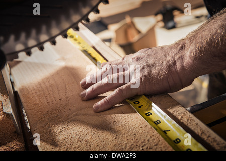 Nahaufnahme eines männlichen Zimmermann mit Maßband in Werkstatt Stockfoto