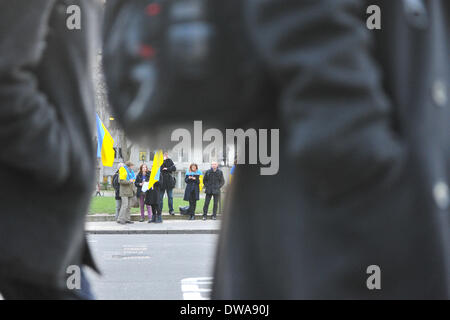 Parliament Square, London, UK. 4. März 2014. Arbeitern und Touristen vorbeiziehen wie ukrainische Demonstranten Flaggen in einem Protest gegenüber Parlament anspruchsvolle Maßnahmen gegen Russland halten. Stockfoto