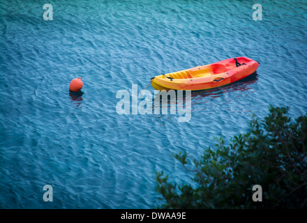 Gelb rot Kunststoff Rettungsboot im blauen Wasser vertäut. Mallorca, Balearen, Spanien im Oktober. Stockfoto