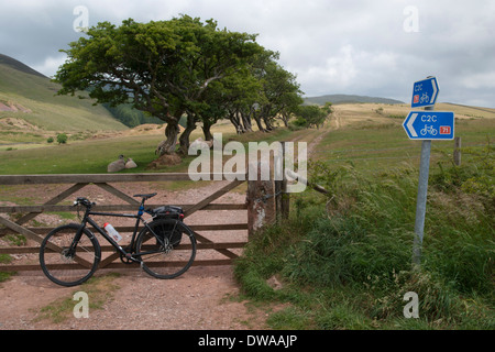 Ein Fahrrad auf dem C2C (SUSTRAN Route 71) gegen ein Feld Tor am Anfang eines Weges an Croasdale, Cumbria, England. Stockfoto