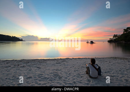 Touristen am Strand sitzen und einer atemberaubenden goldenen Sonnenuntergang hatte Salat, Koh Phangan, Süd-Thailand. Verschwommene mot Stockfoto