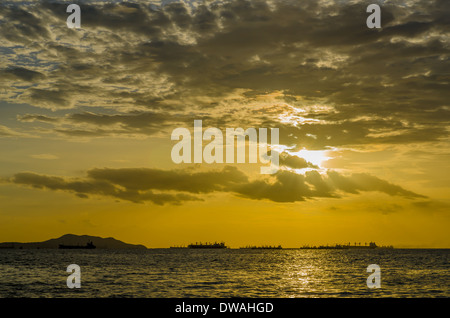 Der Sonnenuntergang leuchtendes gold Farbe hinter eine Marine mit eine schöne Wolke Stockfoto