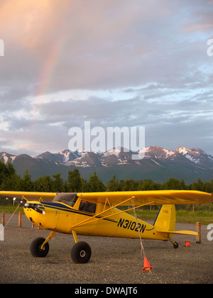 Gelbe Cessna 120 festgebunden bei Sonnenuntergang auf dem Kies Streifen, Merrill Field, Alaska Stockfoto