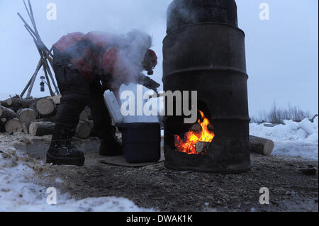 Anchoarge, AK, USA. 4. März 2014. BOB HALLINEN / Anchorage Daily News.Aliy Zirkle füllt ihr Kühler mit heißem Wasser, Hundefutter am Checkpoint Nikolai während 2014 Iditarod Trail Sled Dog Race auf Dienstag, 4. März 2014 zu mischen. Bildnachweis: Bob Hallinen/Anchorage Daily News/ZUMAPRESS.com/Alamy Live News Stockfoto