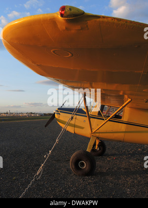 Gelbe Cessna 120 festgebunden bei Sonnenuntergang, Merrill Field, Alaska Stockfoto