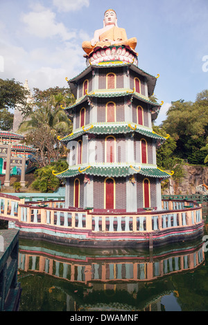 Singapur - 1. Februar 2014: Buddha-Statue sitzt oben auf chinesische Pagode im Themenpark Haw Par Villa. Stockfoto