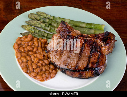 Dicke Schweinekoteletts, Bohnen und Rosenkohl. Stockfoto