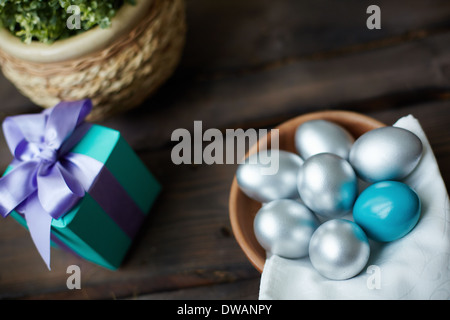 Silberne und blaue Ostereier mit Geschenkbox auf Hintergrund Stockfoto